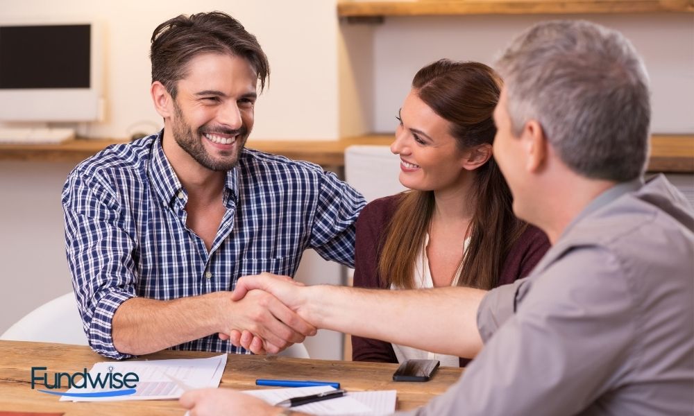 Couple shaking hand to a business financial advisor