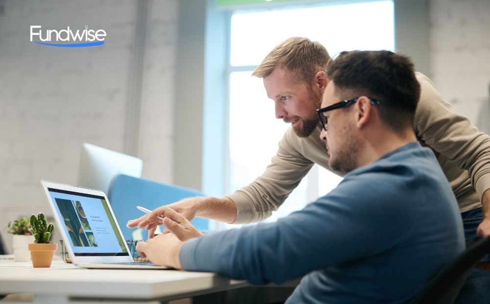 two business owners discussing in front of a laptop