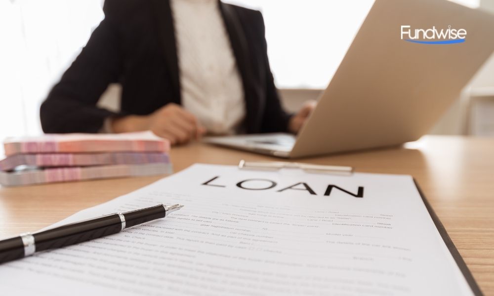 loan document with business woman using laptop on background